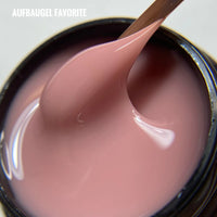 Aufbau Gel Favorite: Pink builder gel with smooth, glossy texture shown in jar with application tool