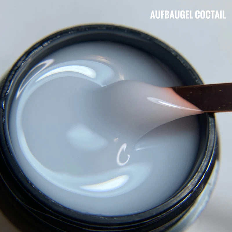 Aufbau Gel Coctail: Milky white builder gel in jar with application spatula showing smooth, creamy texture